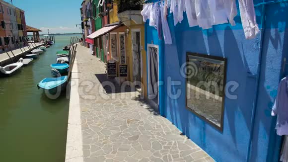 意大利布拉诺岛上五颜六色的创意房屋停泊在人行道上的摩托艇视频的预览图