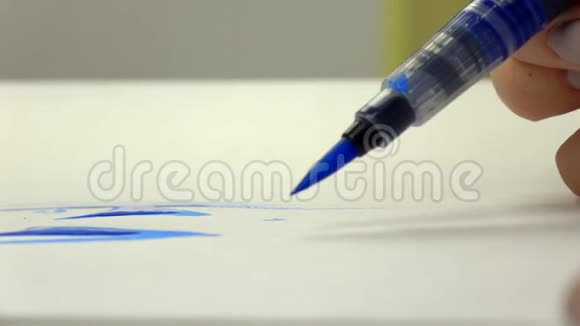 慢镜头艺术家女孩用蓝墨水画一支水彩刷特写视频的预览图
