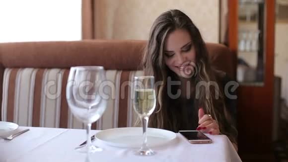 女孩检查电话和喝葡萄酒在城市咖啡馆慢动作视频的预览图