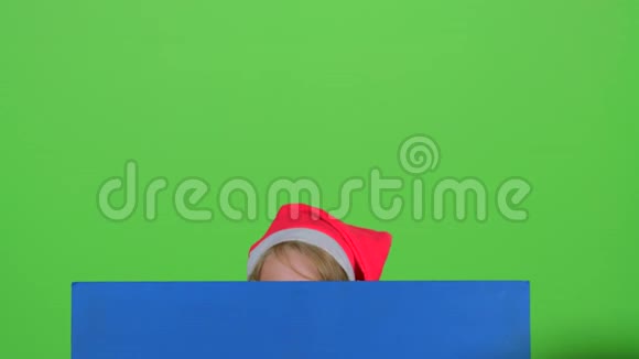 戴着红帽子的少年从绿色屏幕上的木板上出现视频的预览图