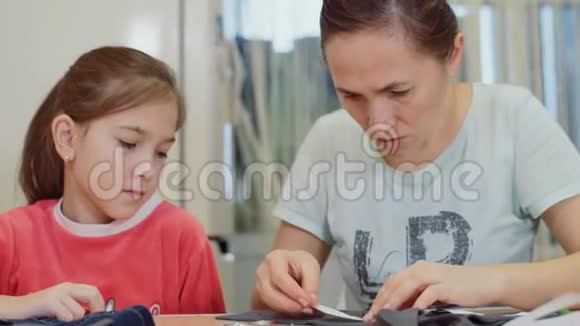 妈妈和小女儿一起为娃娃缝衣服妈妈教他的小女儿给娃娃缝衣服视频的预览图