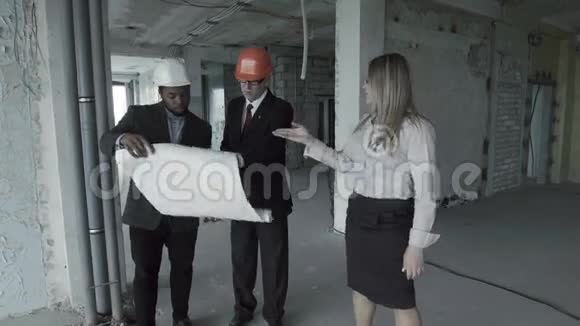 男人女人穿西装戴安全帽的非裔美国人考虑建筑工地内的蓝图视频的预览图