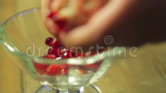 一个女人把石榴粒分成玻璃花瓶视频的预览图