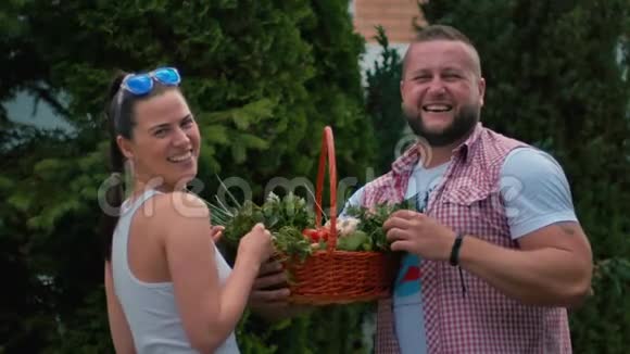 笑的女孩和男人在户外拿着篮子蔬菜的画像视频的预览图