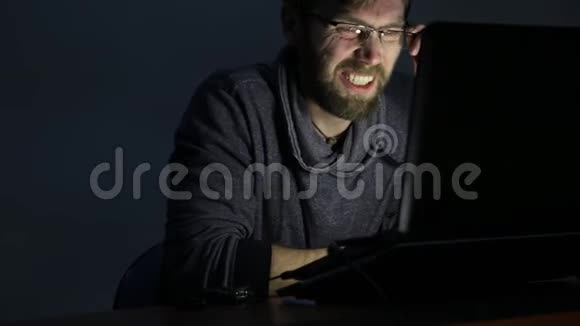 一个满脸沮丧留着胡子的人在笔记本电脑上工作开始高兴起来视频的预览图