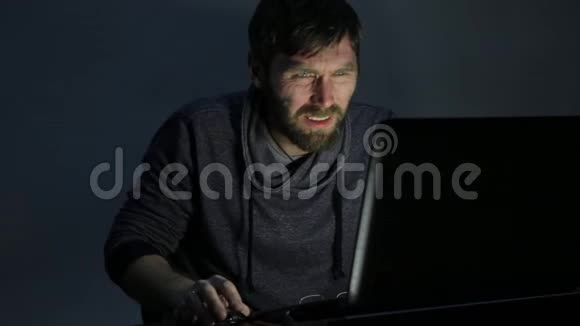 一个满脸沮丧留着胡子的人在笔记本电脑上工作开始高兴起来视频的预览图