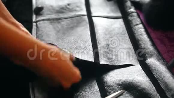 一个女人剪羊皮衣做兜帽把地板剪下来把羊毛从剪下来视频的预览图