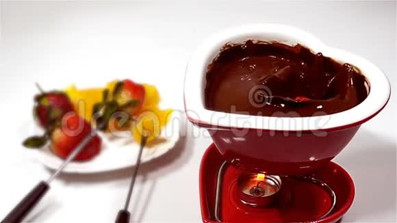 巧克力和水果混合在一起草莓落入融化的巧克力中慢动作视频的预览图