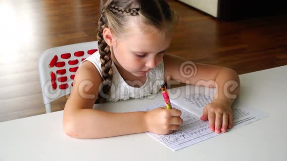一个头上戴着辫子的女孩专心地在餐桌上做作业视频的预览图