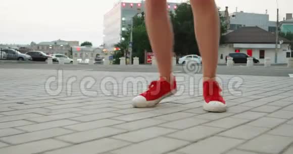 穿红色运动鞋的女孩在人行道上跳舞视频的预览图
