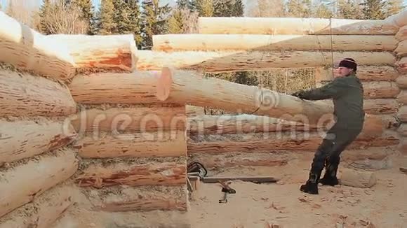 木匠指示用起重机吊起原木加拿大角砌体加拿大风格木头做的木屋视频的预览图
