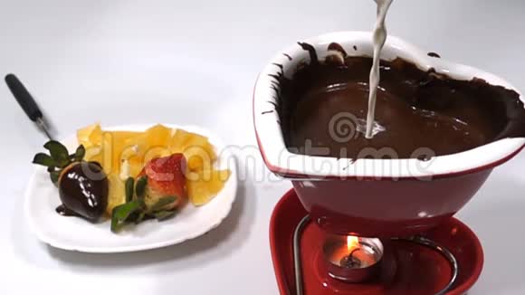 巧克力和水果混合奶油倒入融化的巧克力中慢动作视频的预览图