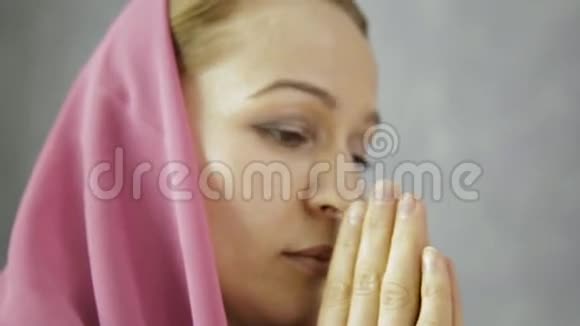 戴头巾的年轻女子在祈祷特写女性手拿着十字架的链子视频的预览图