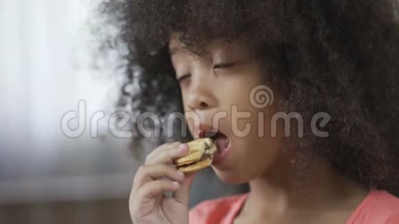 饥饿的非裔美国女孩子吃有食欲的饼干特写视频的预览图