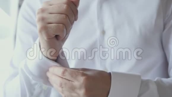 新郎把扣子系在结婚衫上视频的预览图