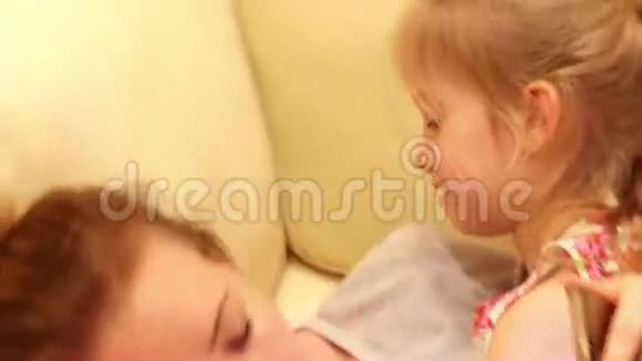 幸福的家庭母女在沙发上玩耍拥抱亲吻视频的预览图