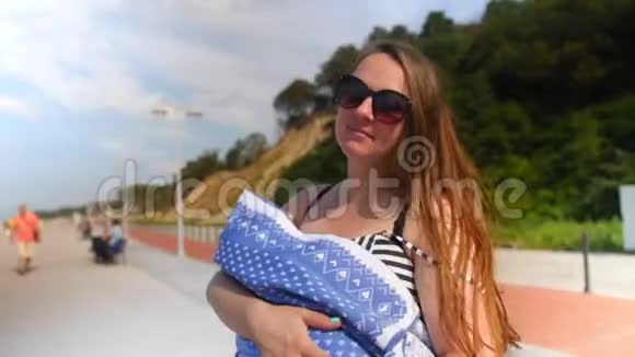 年轻的母亲正把她的孩子抱在怀里家庭母性和人的观念幸福的母亲视频的预览图