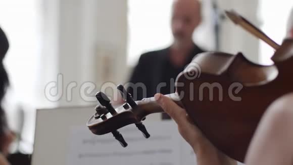 小提琴手在一张纸前演奏小提琴上面有音符视频的预览图