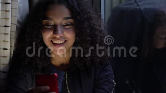 美国黑人少女少女少女利用手机在社交媒体上靠窗视频的预览图