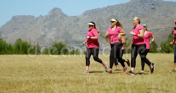 女教练协助在新兵训练营跑步的妇女视频的预览图