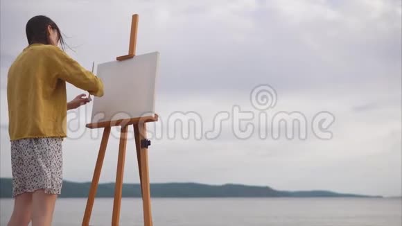 女艺术家准备在河岸上画画布视频的预览图