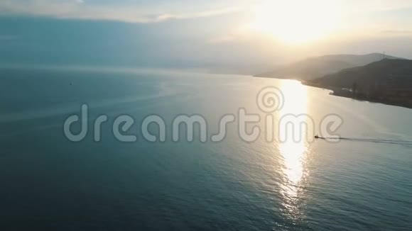 滑板车驾驶黑海鸟瞰4K高高地飞在面对太阳的海面上视频的预览图