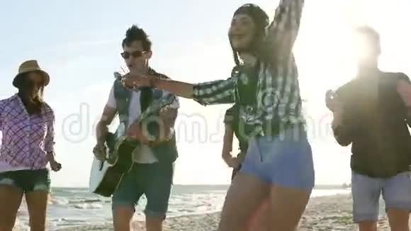 海滩上的夏季派对男孩和女孩一起鼓掌一起跳舞弹吉他在海滩上唱歌视频的预览图