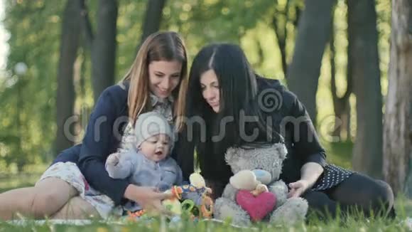 两个女人带着可爱的宝贝在公园的封面上玩玩具视频的预览图