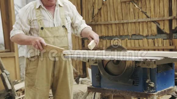 老人用圆锯在机器上锯木头视频的预览图