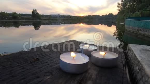 三支药丸蜡烛放在一个古老的木板码头的边缘视频的预览图