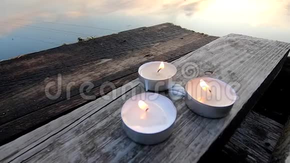 三支药丸蜡烛放在一个古老的木板码头的边缘视频的预览图