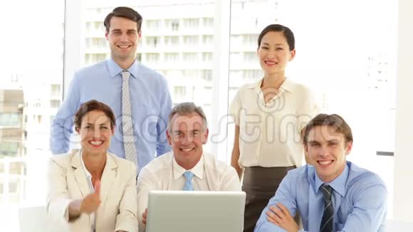 快乐的商业团队在笔记本电脑前摆姿势视频的预览图