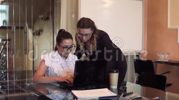 两个在办公室工作的女商人用电脑视频的预览图