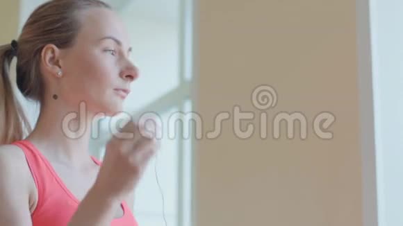 带着耳机的女孩在健身房放松视频的预览图