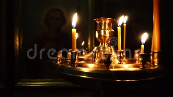 在黑暗的教堂里用燃烧的蜡烛进行视频特写相机锅视频的预览图