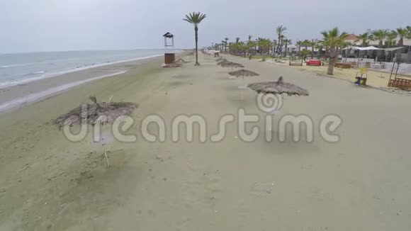 用稻草伞和棕榈树沿着海岸线拍摄旅游和放松视频的预览图