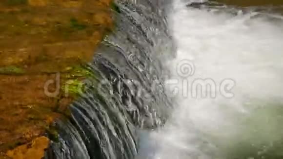 黎明时分美丽的河水流过石块视频的预览图
