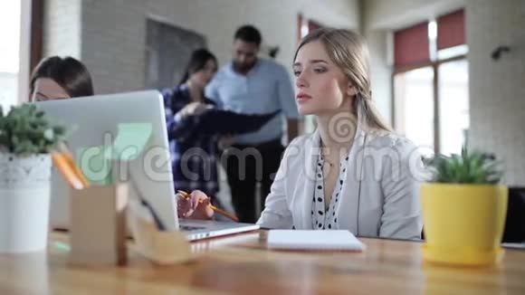 商务女性坐在办公室手提电脑在笔记本上写新想法在笔记本上打字其他视频的预览图