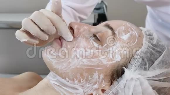 在面部美容手术前在手套中涂上化妆品清洁面罩视频的预览图