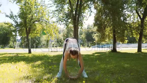 迷人的女跑步者在夏季公园伸展适合女孩在户外做伸展运动视频的预览图