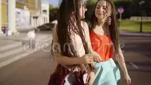 两个快乐的女人带着恐惧走在空荡荡的路上在夏天说话两个时髦女孩笑着跳舞视频的预览图