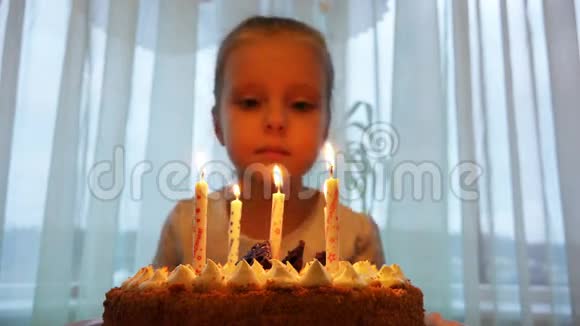 女孩吹灭生日蛋糕上的蜡烛以纪念他的生日视频的预览图