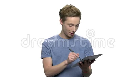 聪明的十几岁男孩在做平板电脑视频的预览图