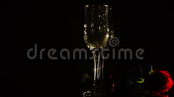 水晶香槟杯和黑色背景的红玫瑰视频的预览图
