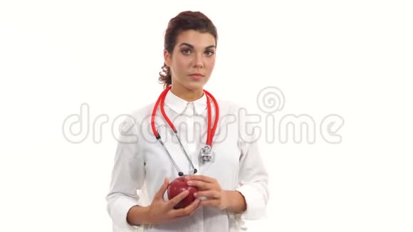 年轻的营养学家捧着红苹果建议健康饮食友好的女医生露出红苹果的微笑肖像视频的预览图
