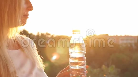 日落时小女孩拿着一个饮水瓶慢动作视频的预览图
