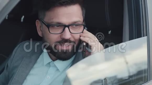 商人坐出租车用智能手机说话视频的预览图