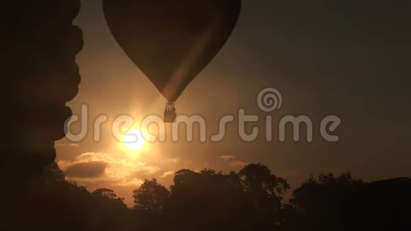 清晨的太阳热气球飞过树木视频的预览图