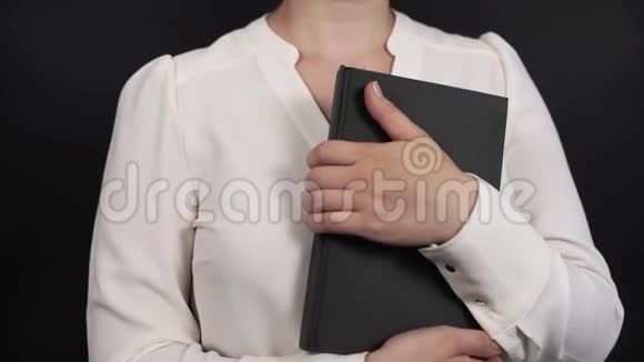 穿着白色衬衫的女孩在黑色的书中视频的预览图