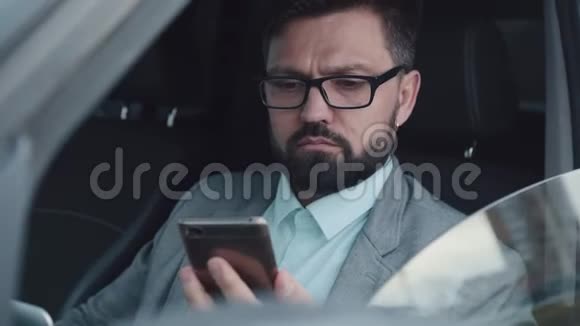 成功的人坐在汽车的后座上用手机说话视频的预览图